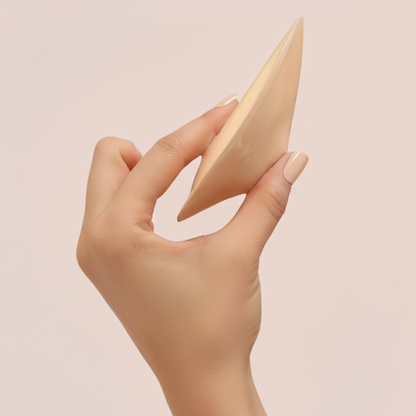 Detailaufnahme des Boostelle Ultra Boost Silikon-Brusteinsatzes, der in einer Hand gehalten wird. Zeigt die dreieckige, ergonomische Form und die dünnen, sich verjüngenden Kanten für einen unsichtbaren Übergang im BH.