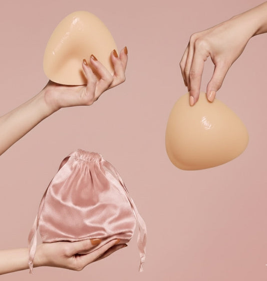 Ultra Boostelle Silikon-Brusteinsätze für Push-up-Effekt, in der Hand gehalten, inklusive rosafarbenem Satin-Aufbewahrungsbeutel. Perfekt für BH und Bikini, unsichtbarer Boost.